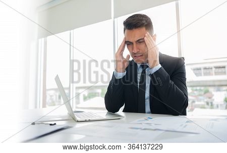 Frustrated Stressed Businessman Feeling Tired In Black Suit Having Migraine During Working At Office