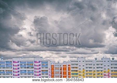 Multi-colored Panel Residential Buildings On The Background Of Dark Storm Clouds, A Dramatic Urban L