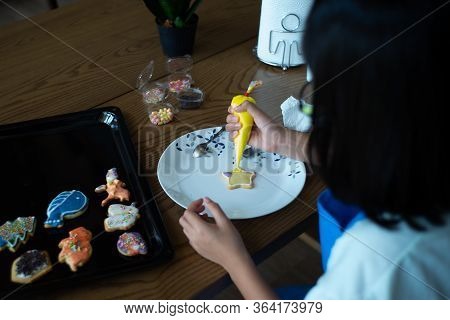 Defocused Back Portrait Of Boy Decorating The Cookie Surface By Squeezing The Liquid Sugar