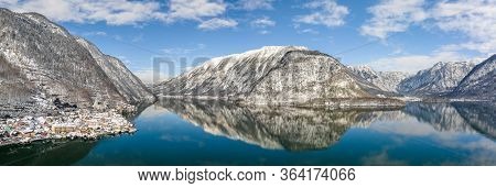 Aerial Panoramic Drone Shot Of Snow Mountains By Halstatt Lake And Village In Snow Under Blue Cear S