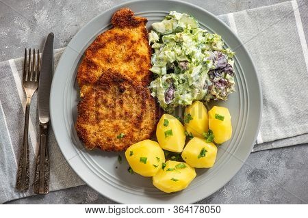 Chop Pork Cutlets , Served With Boiled Potatoes And Salad.