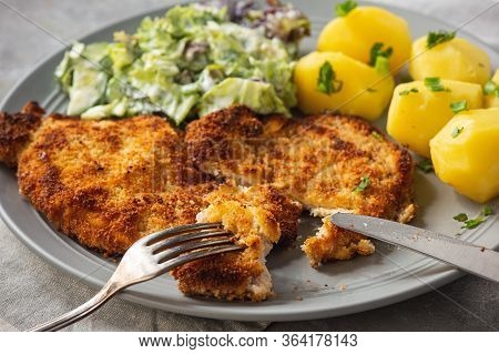 Chop Pork Cutlets , Served With Boiled Potatoes And Salad.