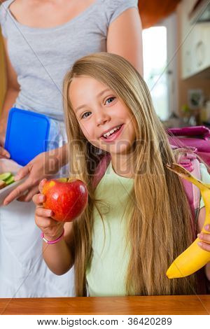 Aile - sabah ve bir aperatif okul çocukları için kahvaltı yapmak anne