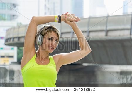 Woman In Sport Wear  Doing Stretching Exercise And Listening Music.concept Of Healthy, Fitness, Spor