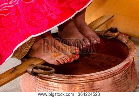 Close Up Shot Of Feet Of Bride And Groom During Traditional Hindu Wedding Ceremony. Bride Relatives 