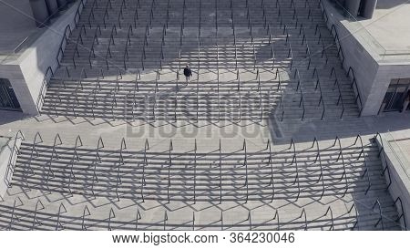 Symmetrical Shot. A Man Climbs The Stairs To The Stadium