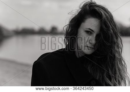 Close Up Portrait Of The Curly Woman Wearing The Coat