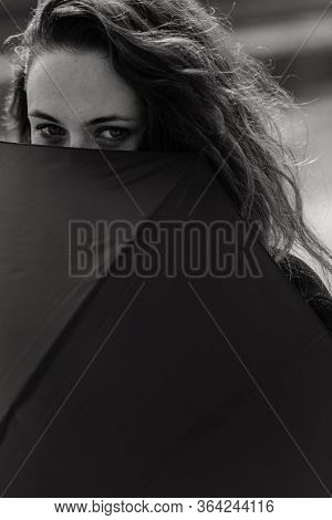 Closeup Portrait Of The Woman Looking Out Of The Umbrella