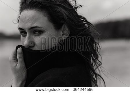Closeup Portrait Of The Woman Looking Out Of The Coat Collar