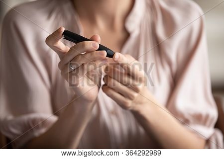 Close Up Young Woman Measuring Glucose Level, Using Lancet Pen