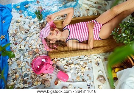 The Girls Is Lying On A Fictional Beach Near The Sea Or Ocean, Sunbathes.