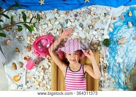 The Girls Is Lying On A Fictional Beach Near The Sea Or Ocean, Sunbathes.