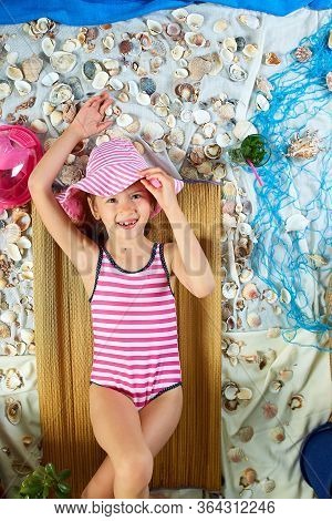 The Girls Is Lying On A Fictional Beach Near The Sea Or Ocean, Sunbathes.