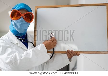 Muslim female doctor with blank whiteboard