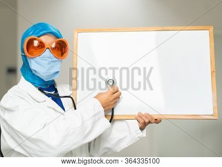 Muslim female doctor with blank whiteboard