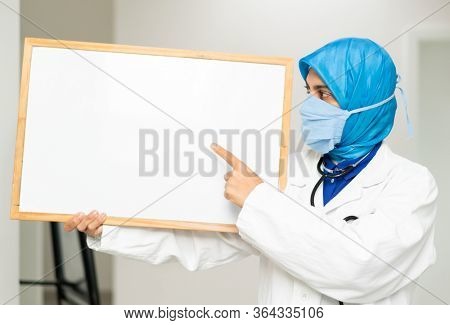 Muslim female doctor with blank whiteboard