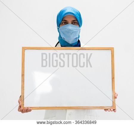Muslim female doctor with blank whiteboard