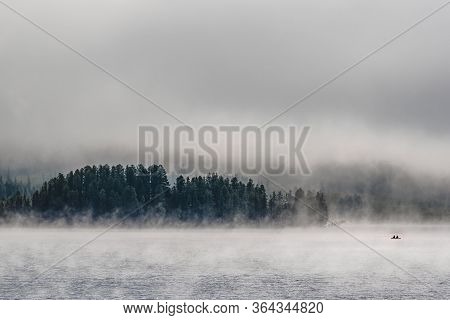 Boat With Fishermen On A Mountain Lake Covered With Fog In The Ulagansky District Of The Altai Repub