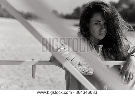 The Portrait Of Serious Curly Woman Standing Near The Fence