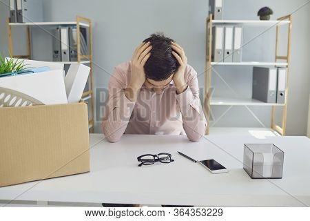 Unemployment. Dismissal. Dismissed Businessman Is Upset With A Cardboard Box Holding His Head In His