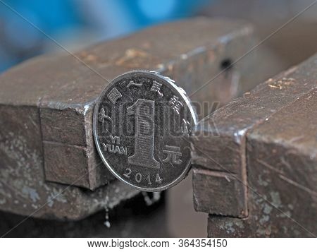 Yuan Coin Clamped In A Metal Vise. Currency Under The Onslaught, The Concept Of Financial Problems A