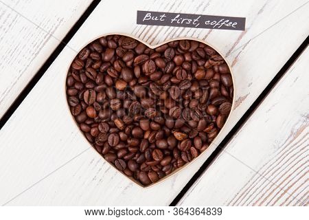 Close Up Roasted Coffee Beans Forming Heart Form. But First Coffee. Top View Flat Lay.