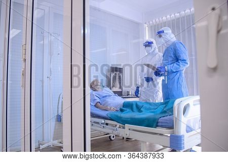 Infected Patient On Takecare Of Doctor And Nurse With X-ray Lung In Quarantine Lying On Bed In Hospi