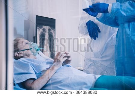 Infected Patient On Takecare Of Doctor And Nurse With X-ray Lung In Quarantine Lying On Bed In Hospi