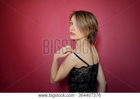 Young Woman With Short Hair Dressed In Black Lace Bustier And Blue Jeans Is Posing In The Studio On 