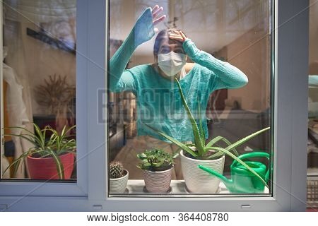 Woman With Medical Mask On Their Faces Looking Through Window, Stay At Home, Selfisolation To Preven