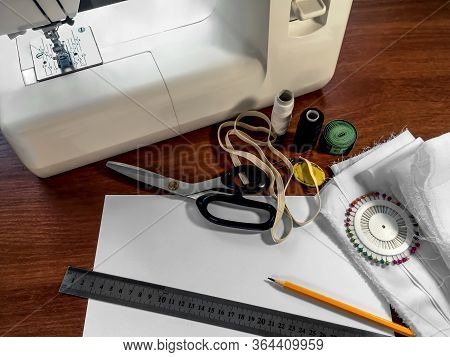 White Fabric, A Sewing Machine, Scissors, Ball Head Pins, Spools Of Thread, An Elastic Band, A Sheet