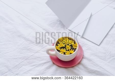 Cup With Yellow Flowers On A White Bed. Spring Background.