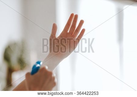 Woman Uses A Protective Spray Against Germs On Her Hands At Home, During A Virus Outbreak.