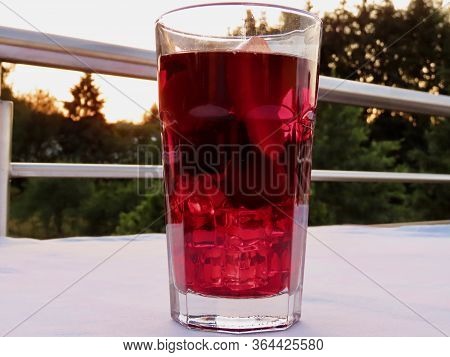 Cold Sangria - Close Up Of Big Glass With Ice, Cherries, Apple Slices In Summer Heat. Blurry Backgro