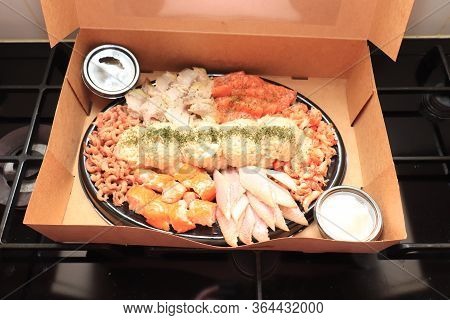 Serving Plate With Fresh Luxurious Seafood And Sauce In Take Away Carton Box