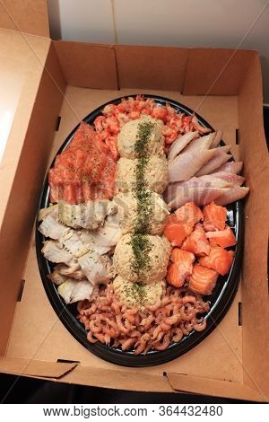 Serving Plate With Fresh Luxurious Seafood And Sauce In Take Away Carton Box