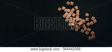Brown Cane Sugar In Cubes On A Black Background. Still Life. Carbohydrates And Non-diet Food. Calori