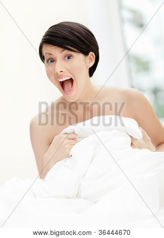 Halfnaked kvinde knus eiderdown, hvid baggrund