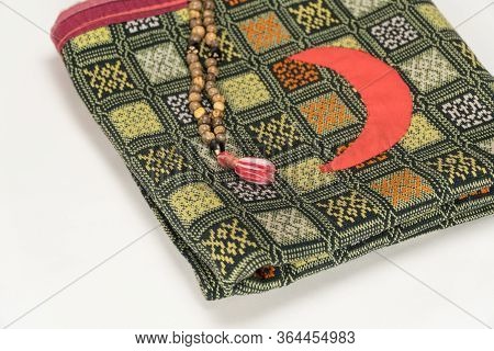 Muslim Prayer Beads On The Prayer Mat With The Crescent Symbol On а White Background. Islamic And Mu