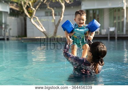 Asian Family, Beautiful Mother And Cute Baby Boy Happinese In Swimming Pool, At Luxury Resort.