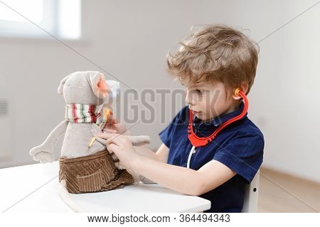 A Little Boy Plays A Doctor And Measures The Temperature With A Thermometer Toy Rat. Detects Coronav