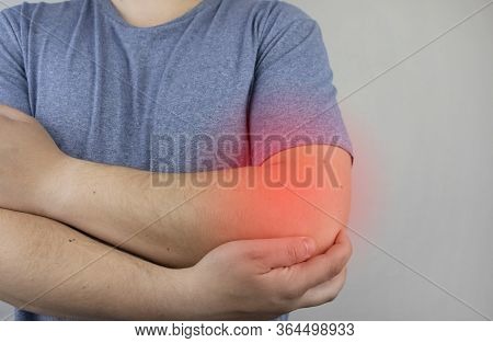A Man Suffers From Elbow Pain. Damaged Elbow Joint, Bone Fracture, Or Sprain. Hand Injury And Flexio
