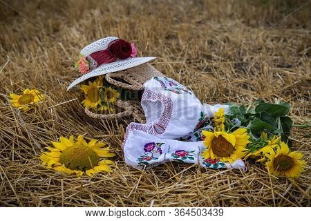 Still Life Of Hats And Baskets With Sunflowers On A Mowed Field