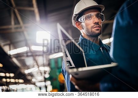 Industry Maintenance Engineer Wearing Uniform And Safety Helmet Under Inspection And Checking Produc