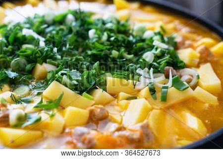Background Stewed Potatoes With Meat Sprinkled With Fresh Herbs Close Up