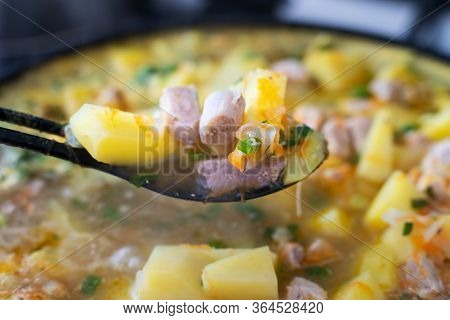 Background Stewed Potatoes With Meat On A Plastic Black Spoon Close Up