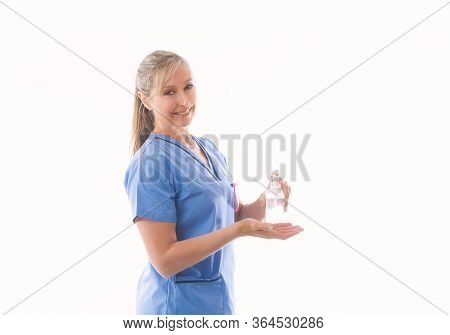 Nurse Or Healthcare Professional Demonstrating Use Of Hand Sanitizer.  Covid-19 Coronavirus Pandemic