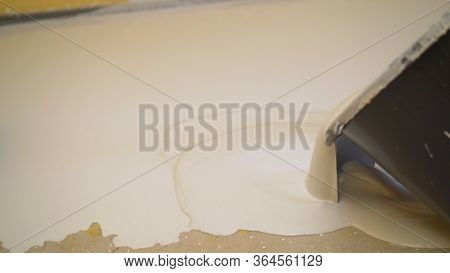 Builders Pour Mortar To Level The Floor. Workers Fill The Self-priming Floor On The Concrete Floor. 