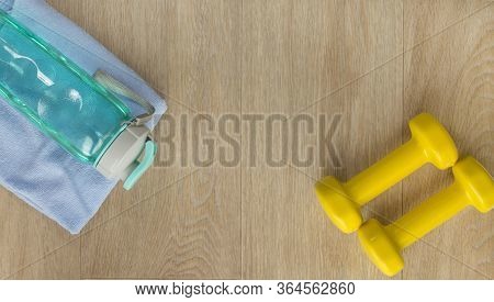 Fitness Equipment On Wooden Floor. Dumbbells And Bottle Of Water. Cope Space
