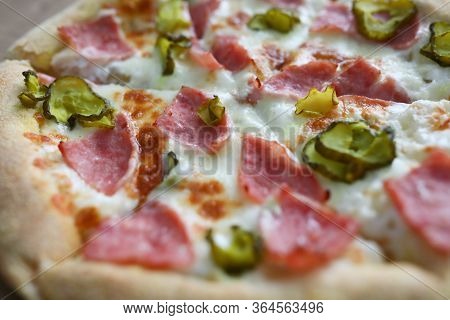 Close-up Of Homemade Delicious Round Shaped Pizza. Hot Yummy Salami Double Cheese Parmesan Tomatoes 